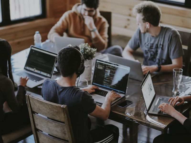 Team bei der Zusammenarbeit am Laptop